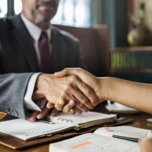 Handshake over a desk with an open planner