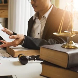 Lawyer advising a client beside law books, scales and a gavel